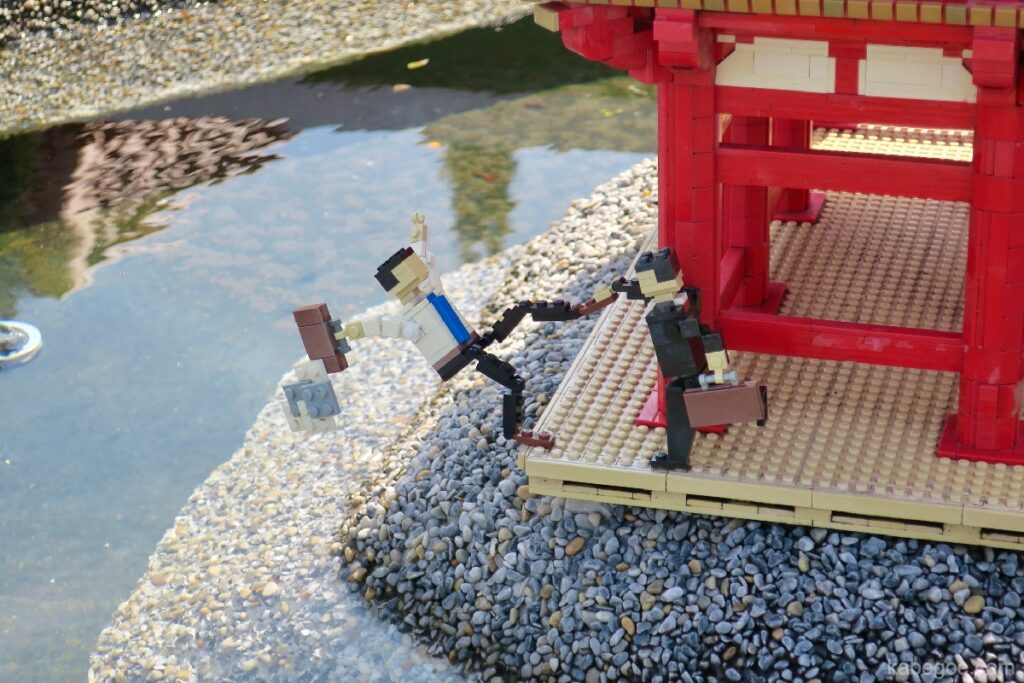 Personas que están a punto de caer en el estanque de Legoland Miniland
